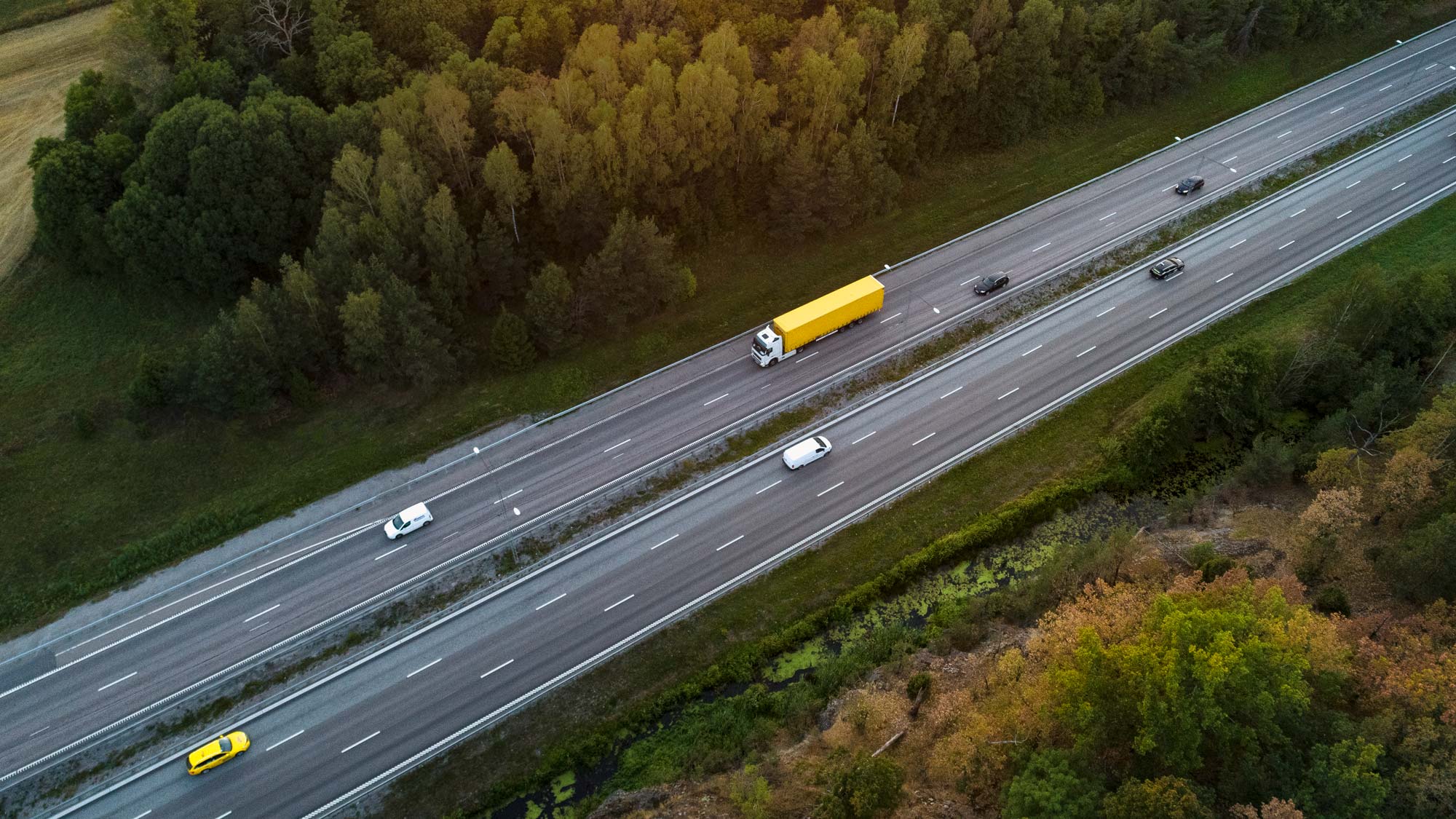 Gul lastbil som kör på en motorväg