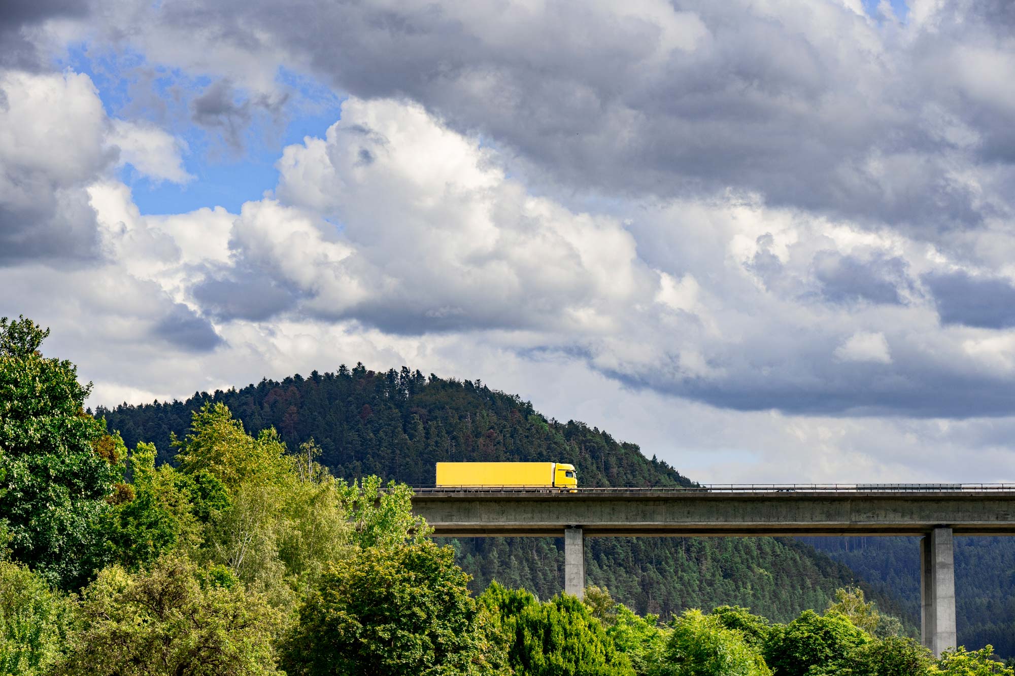 Gul lastbil som kör på en bro